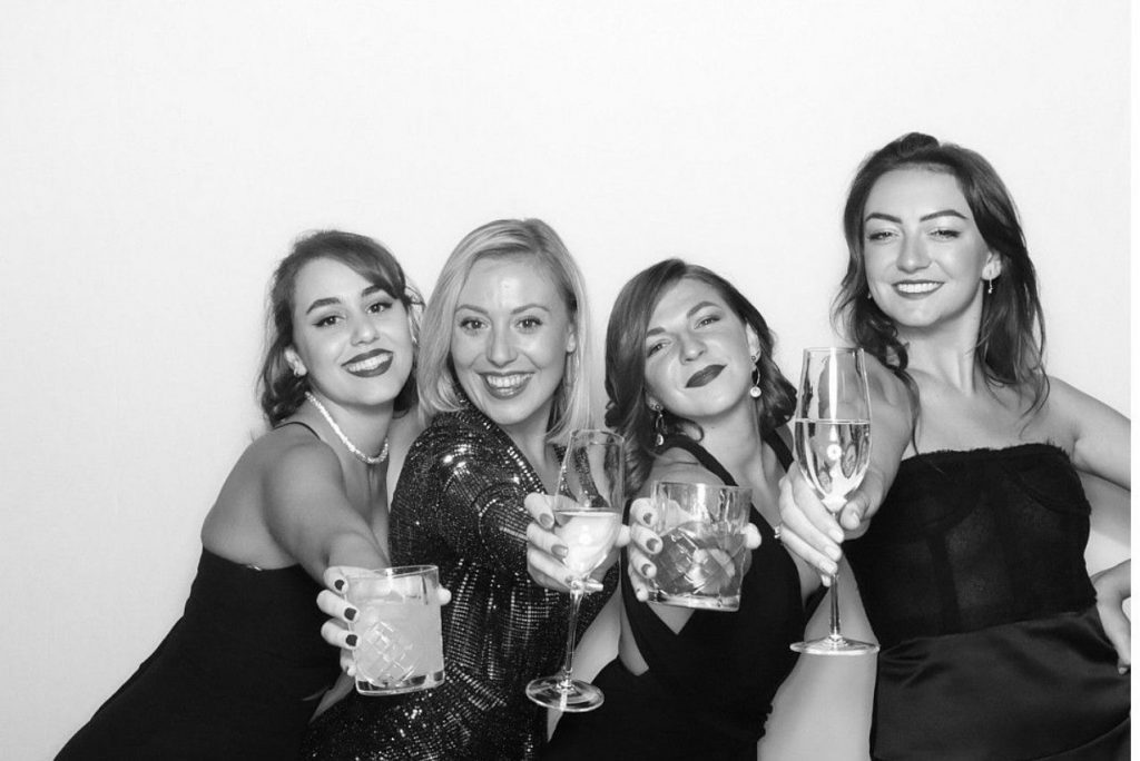 group of ladies posing for black and white photo booth