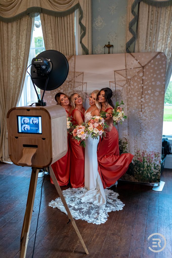 bride and bridesmaids posing for photos at the photo booth