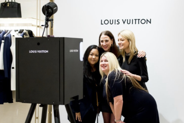 Louis Vuitton employees posing for photos on the branded photo booth